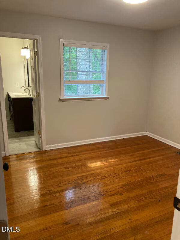 1505 Woodland Road Garner, NC 27529 - Photo 10 of 19 a view of an empty room with wooden floor and a window