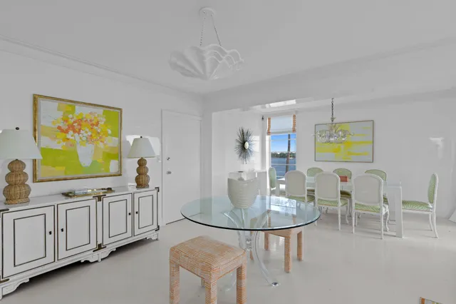 a dining room with furniture a chandelier a mirror and a flat screen tv