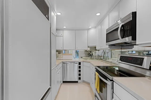 a kitchen with stainless steel appliances a sink stove and microwave