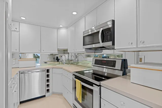 a kitchen with appliances a sink and cabinets
