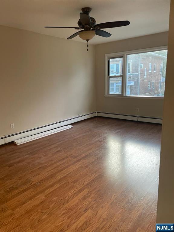 28 Boyd Street Lodi, NJ 07644 - Photo 2 of 7 wooden floor in an empty room with a window