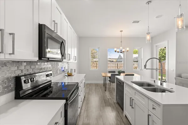 a kitchen with a sink stove top oven and refrigerator