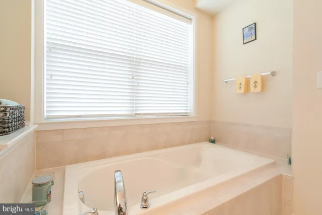a white bath tub sitting in a bathroom next to a window