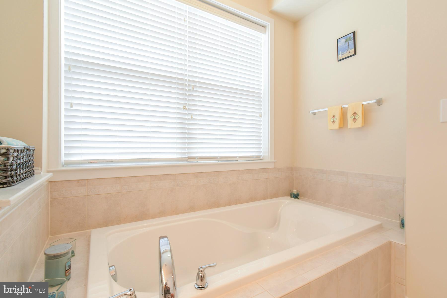 107 70th Street, Unit 10F Ocean City, MD 21842 - Photo 15 of 33 a white bath tub sitting in a bathroom next to a window