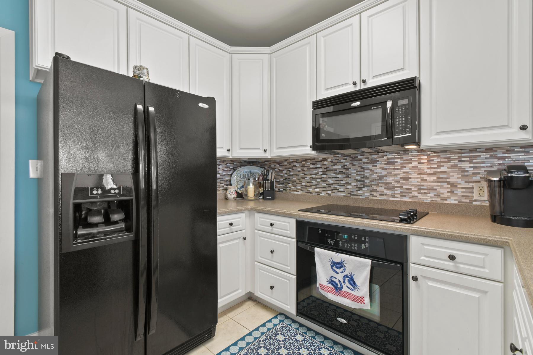 107 70th Street, Unit 10F Ocean City, MD 21842 - Photo 7 of 33 a kitchen with white cabinets and stainless steel appliances