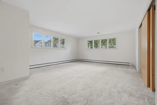 an empty room with windows and closet
