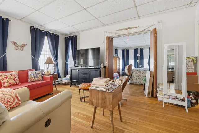 a living room with furniture a flat screen tv and a table