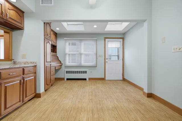 a view of a kitchen with a sink and dishwasher with wooden floor