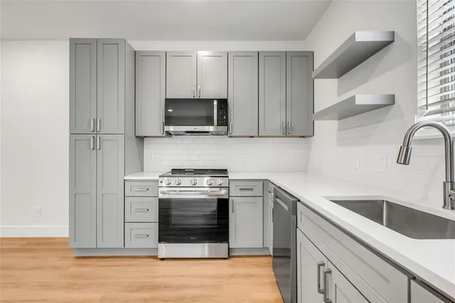 a kitchen with stainless steel appliances granite countertop a stove and a sink