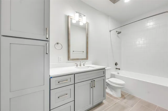 a bathroom with a double vanity sink toilet mirror and shower