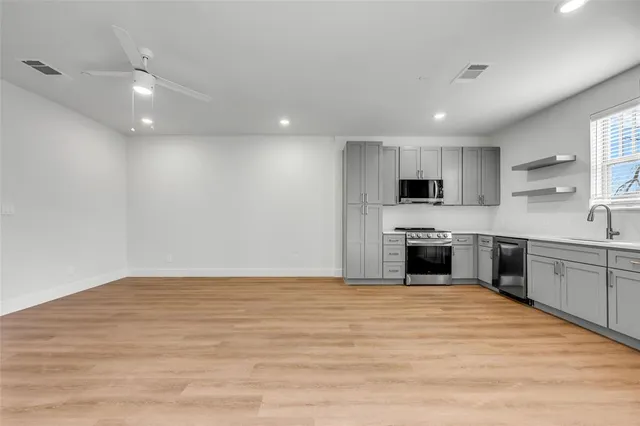 a large kitchen with granite countertop a large counter top stainless steel appliances and cabinets