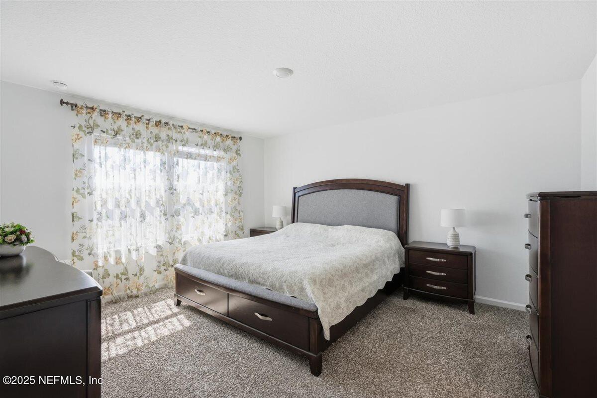 137 Tordera Ln Street St. Augustine, FL 32084 - Photo 21 of 43 a bedroom with a bed and a window