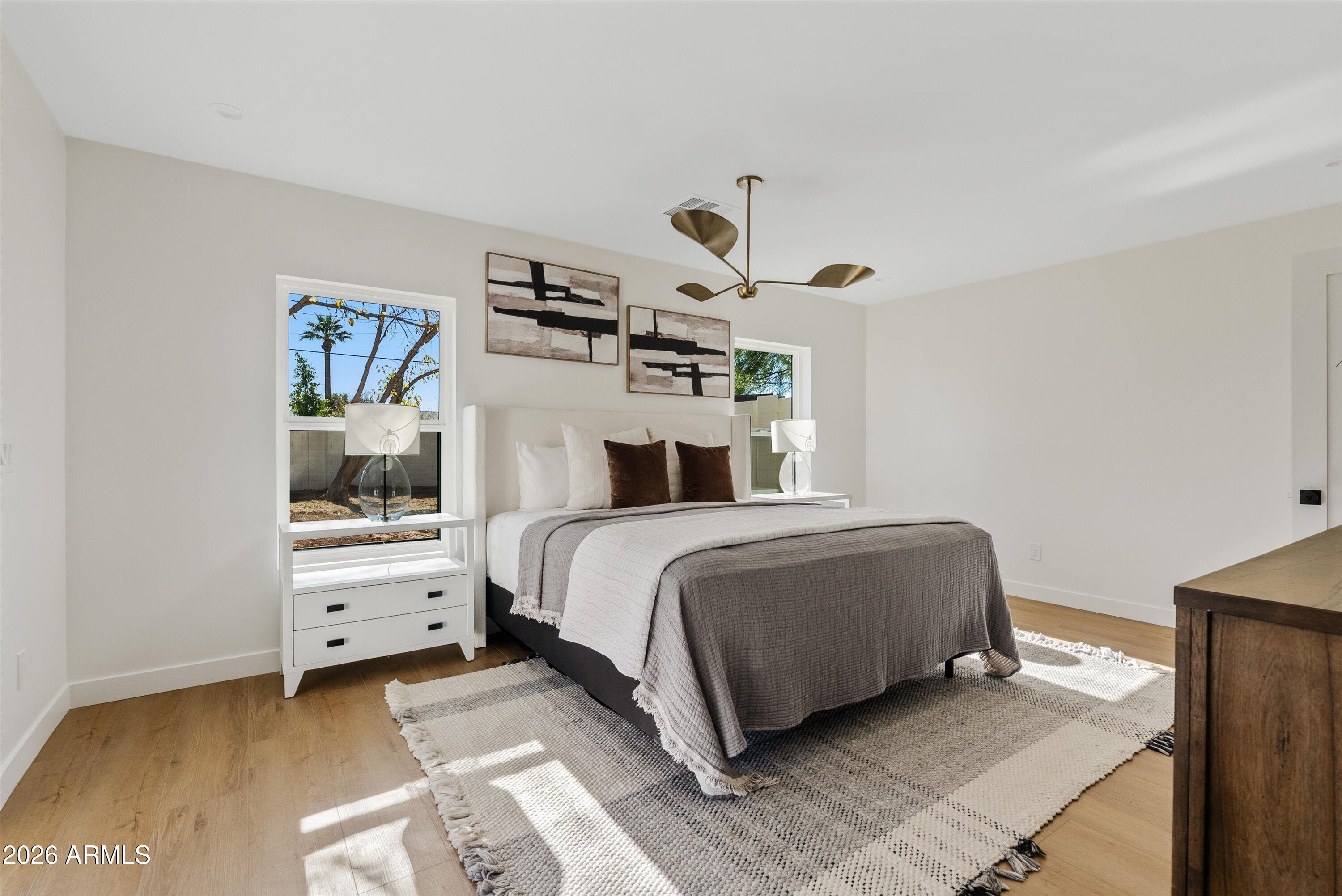 2941 East Cheery Lynn Road Phoenix, AZ 85016 - Photo 18 of 25 a bedroom with a large bed and a chandelier