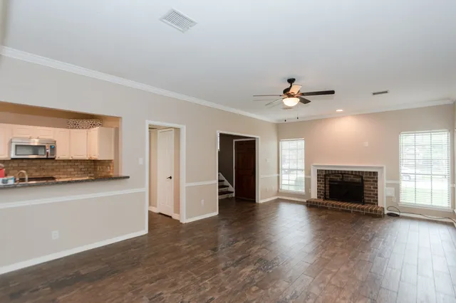 a view of a kitchen with a sink a microwave and cabinets