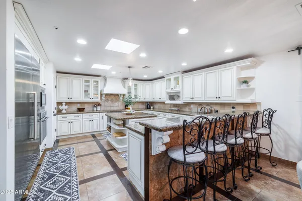 a living room with couches and kitchen view with wooden floor