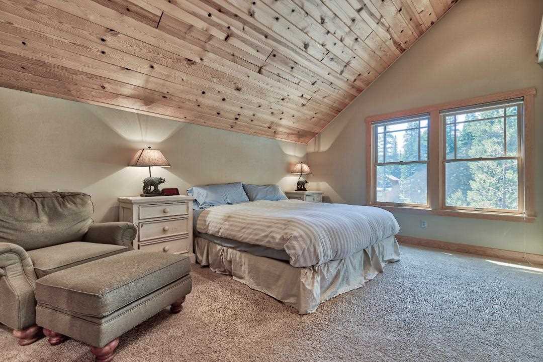 135 Alpine Meadows Road, Unit 32 Alpine Meadows, CA 96145 - Photo 11 of 20 a spacious bedroom with a bed a couch and window