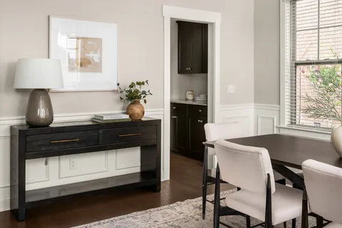 a view of a brick house with a large window and wooden fence