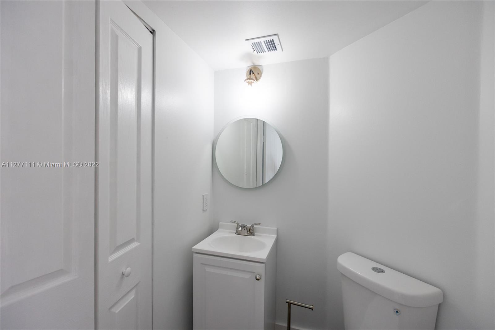 2351 Douglas Road, Unit 908 Miami, FL 33145 - Photo 26 of 37 a bathroom with a toilet a sink and mirror