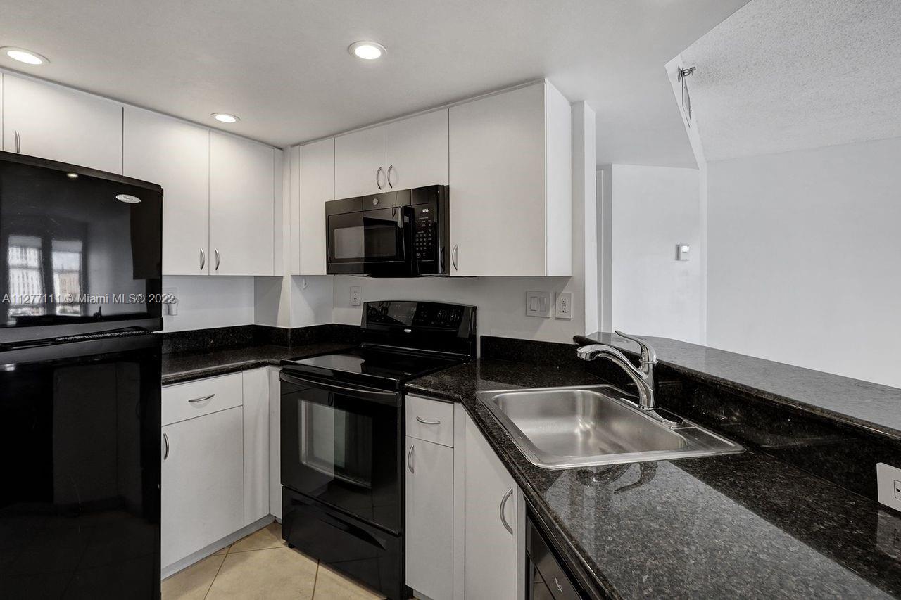 2351 Douglas Road, Unit 908 Miami, FL 33145 - Photo 9 of 37 a kitchen that has a sink and a stove top oven
