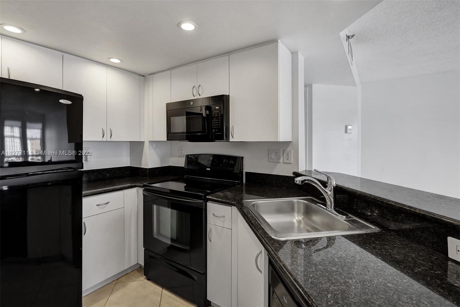 2351 Douglas Road, Unit 908 Miami, FL 33145 - Photo 10 of 37 a kitchen that has a sink and a stove top oven
