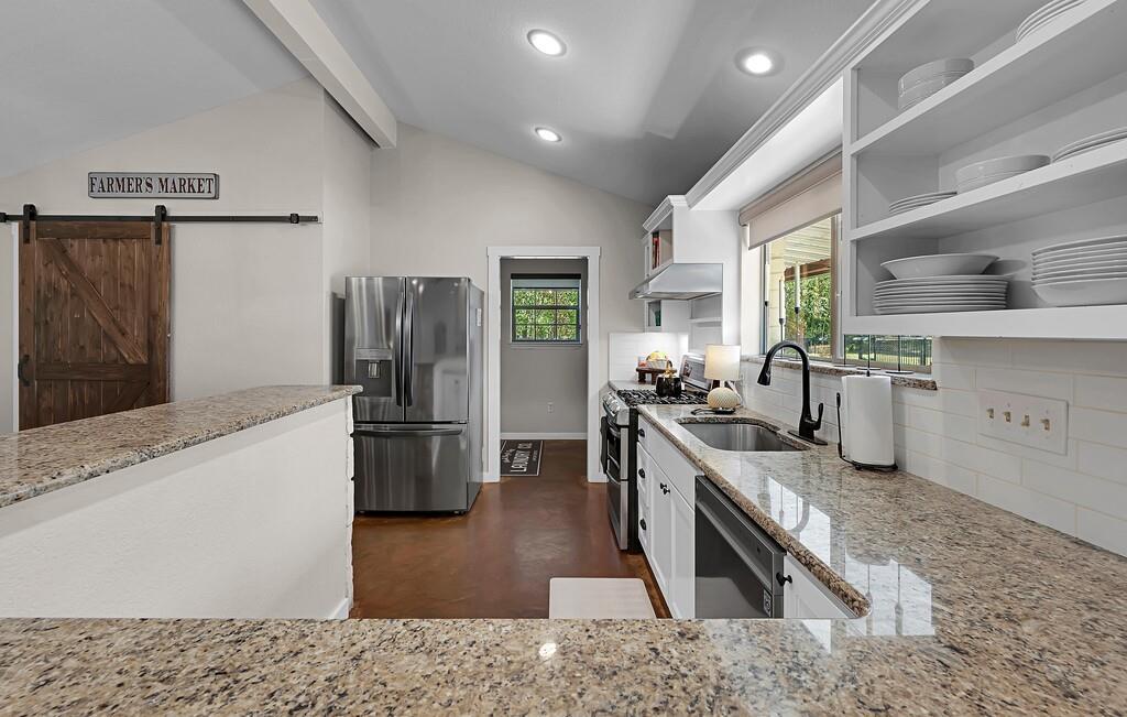 655 Buster Chatham Road Waco, TX 76705 - Photo 11 of 40 a kitchen with stainless steel appliances granite countertop a refrigerator a stove and a sink