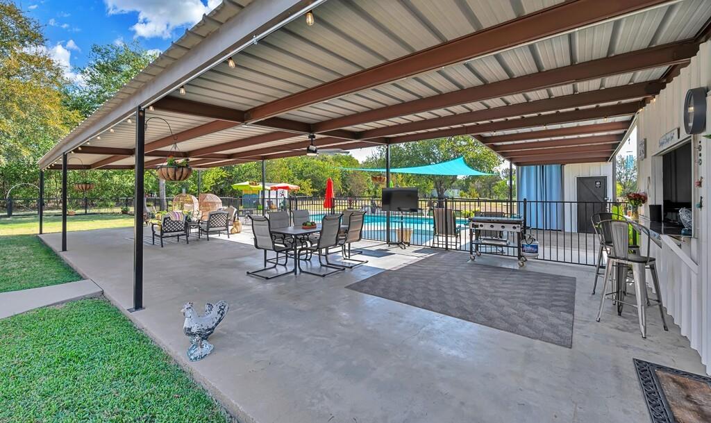 655 Buster Chatham Road Waco, TX 76705 - Photo 24 of 40 a view of a backyard with table and chairs under an umbrella with a barbeque