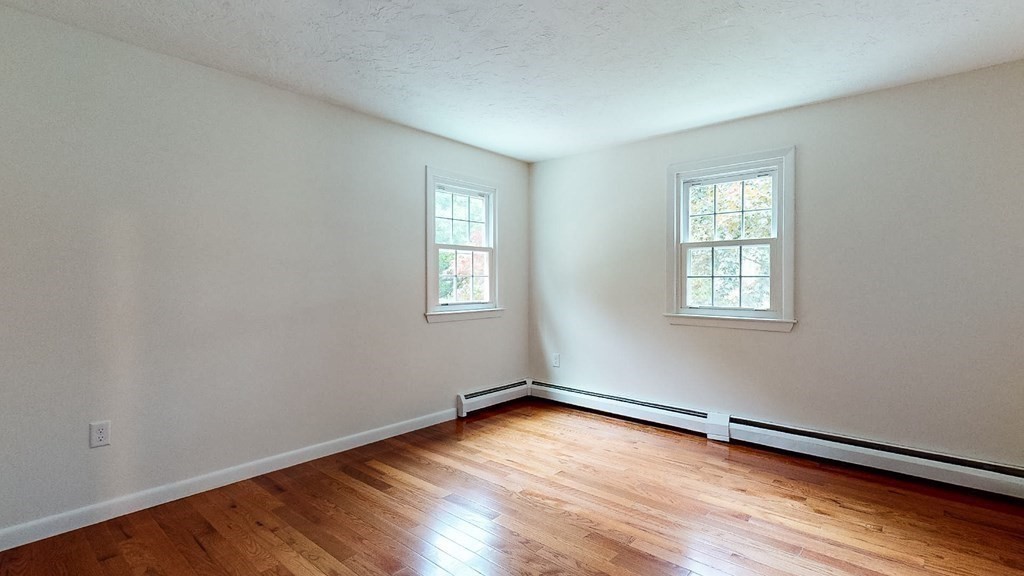 34 Heritage Road Sutton, MA 01590 - Photo 16 of 33 an empty room with wooden floor and windows