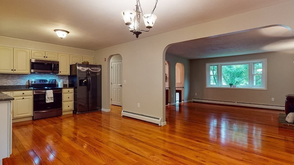 34 Heritage Road Sutton, MA 01590 - Photo 4 of 33 a view of a kitchen with a stove wooden floor windows and a chandelier