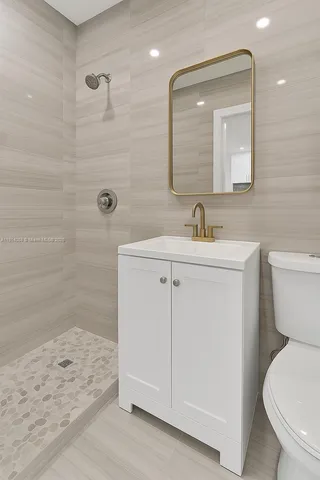 a bathroom with a toilet sink and mirror