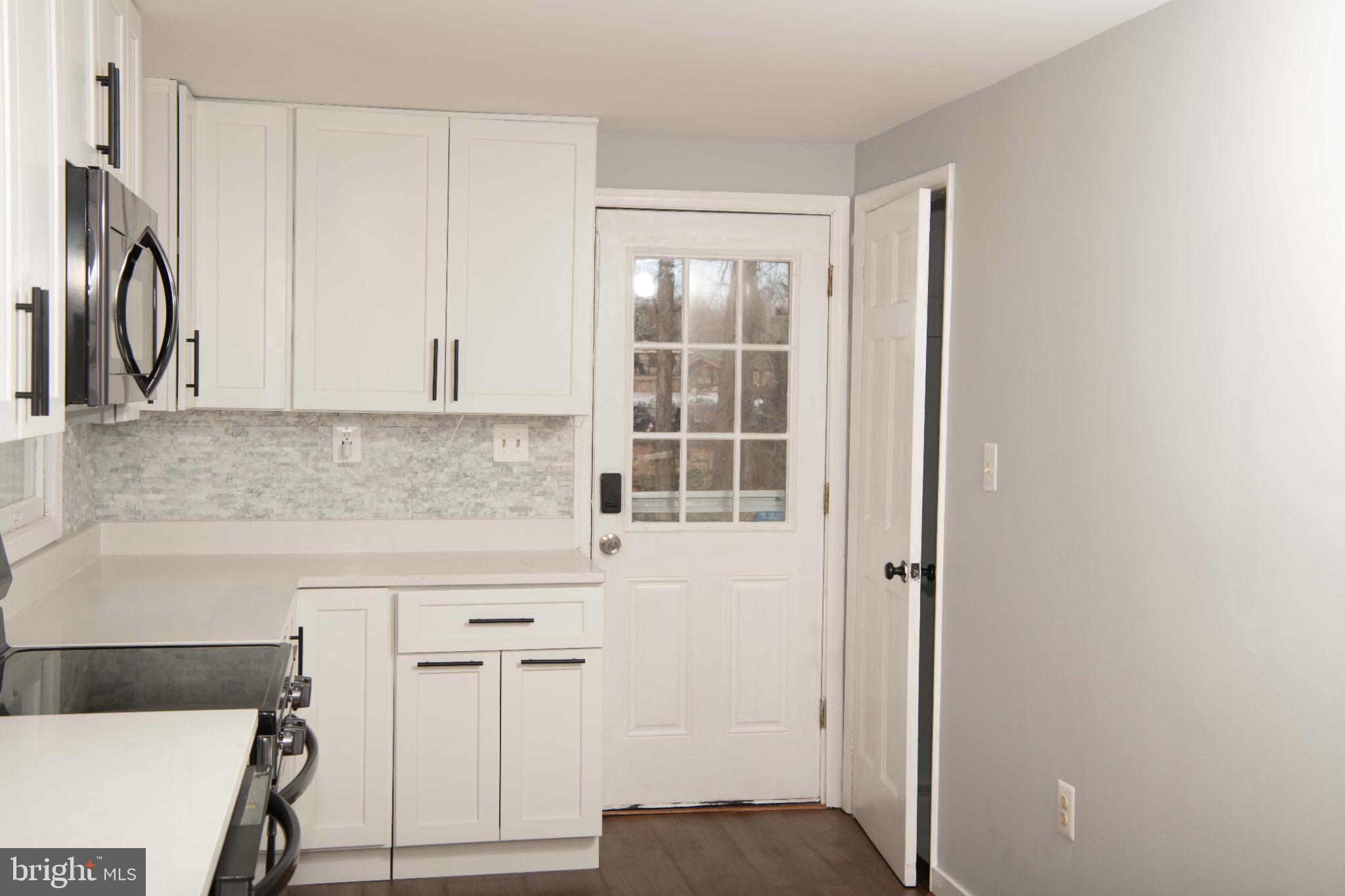 4785 Mountain Road Pasadena, MD 21122 - Photo 4 of 30 Modern kitchen with sleek white cabinetry.