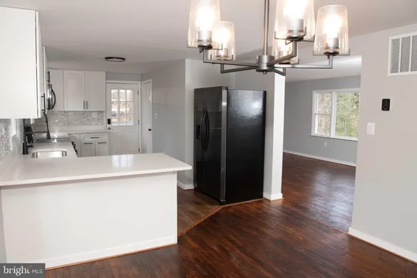 a kitchen with stainless steel appliances a sink stove and wooden floor