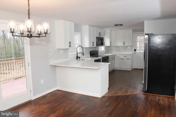 a kitchen with a sink cabinets stainless steel appliances and a window
