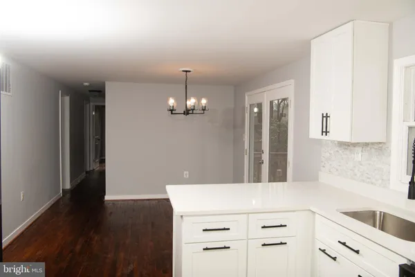 a kitchen with kitchen island granite countertop wooden cabinets and refrigerator
