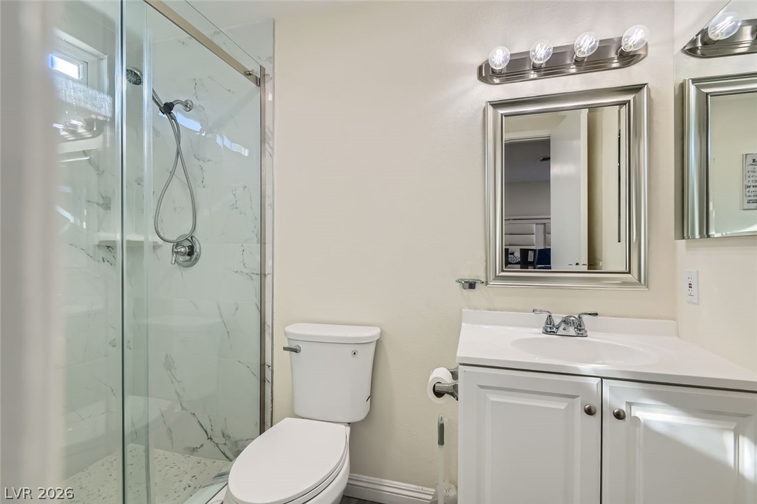 3665 Bronco Road Las Vegas, NV 89103 - Photo 15 of 28 A well-appointed bathroom with a clear glass shower enclosure and modern vanity.