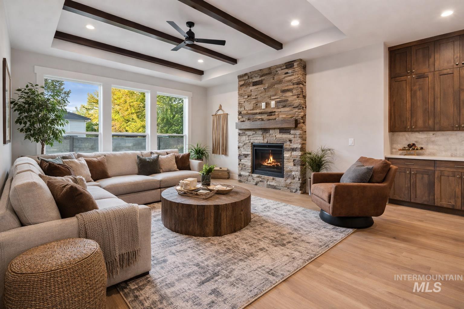 2147 East Blakehurst Avenue Kuna, ID 83634 - Photo 4 of 43 Living area with light wood-style flooring, a ceiling fan, a tray ceiling, a fireplace, and recessed lighting