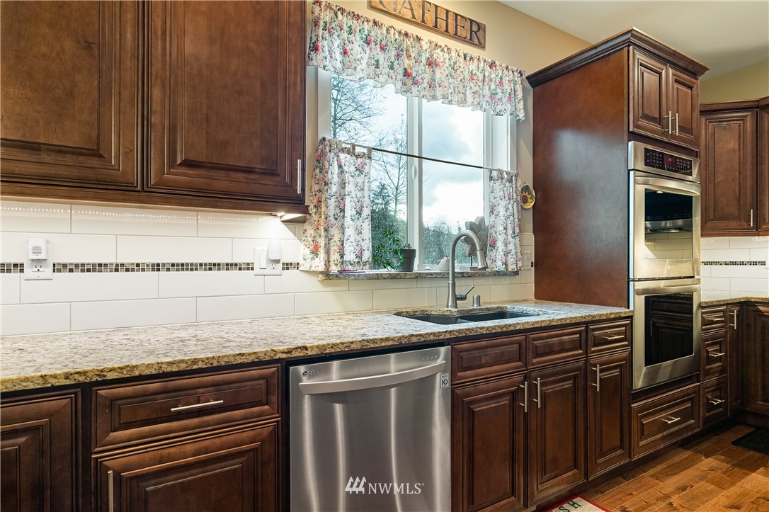 6800 Goodwin Road Everson, WA 98247 - Photo 16 of 40 a kitchen with granite countertop stainless steel appliances a sink stove and cabinets