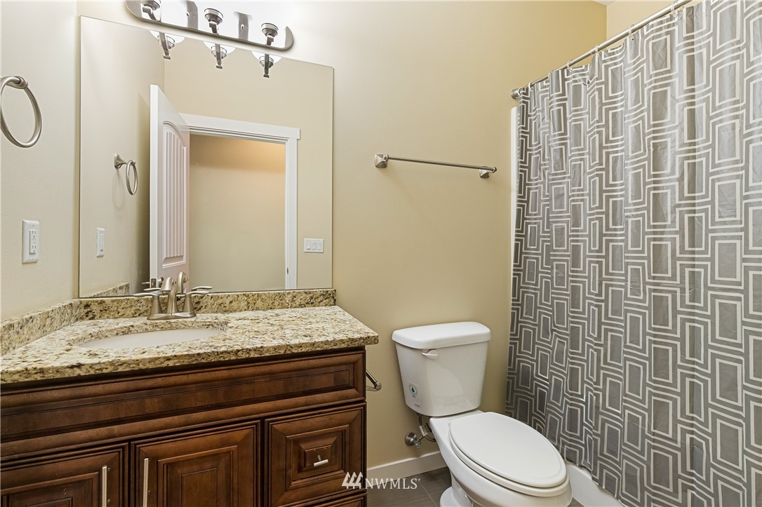 6800 Goodwin Road Everson, WA 98247 - Photo 27 of 40 a bathroom with a granite countertop toilet sink and shower
