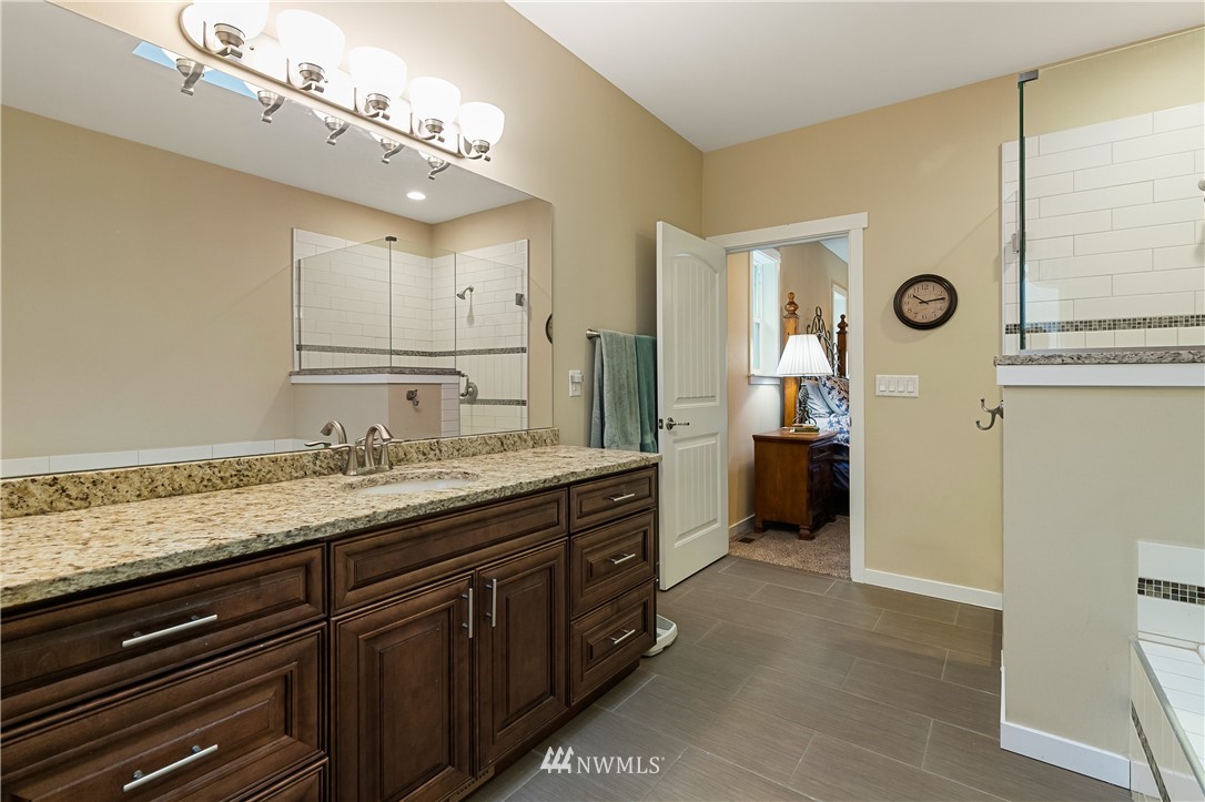 6800 Goodwin Road Everson, WA 98247 - Photo 33 of 40 a spacious bathroom with a granite countertop sink a mirror and a shower
