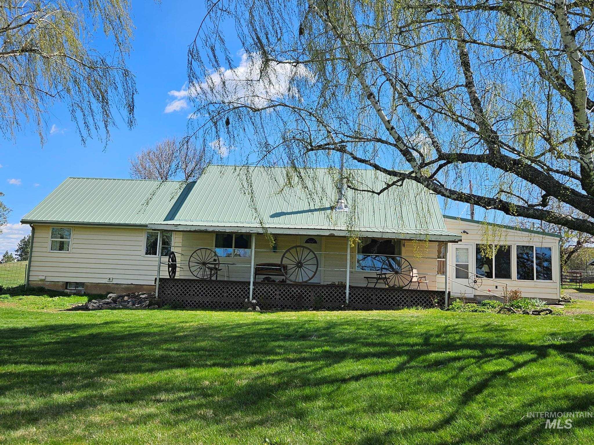 1361 Battle Ridge Road Kooskia, ID 83539 - Photo 1 of 1 Single-story residence featuring a light green metal roof, cream-colored siding, and a full-length covered porch