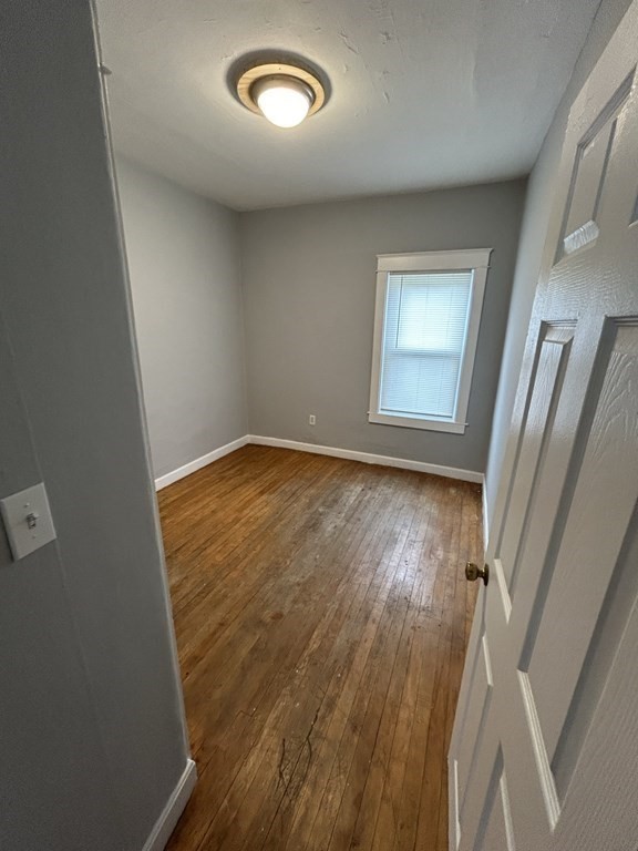 623-631 Birch Street, Unit 1 Fall River, MA 02724 - Photo 14 of 17 an empty room with wooden floor and entrance