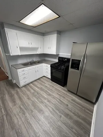 a kitchen with granite countertop a refrigerator stove and sink