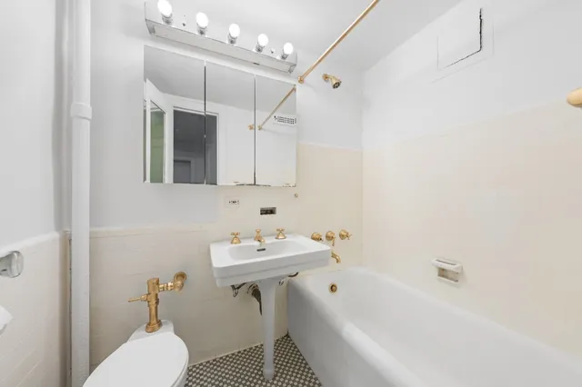 a bathroom with a sink a toilet a mirror and shower