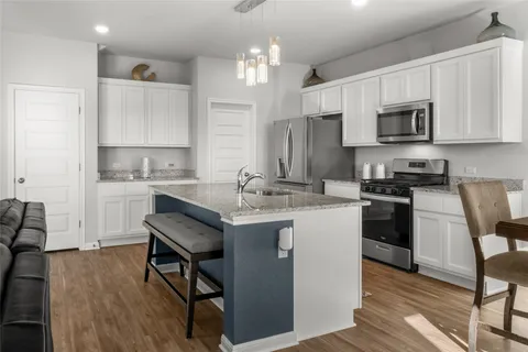 a kitchen with a sink cabinets and wooden floor