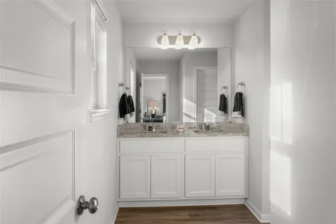 a bathroom with double vanity and a mirror