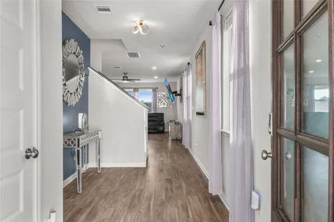 a view of a hallway with wooden floor and staircase