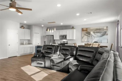 a living room with lots of furniture and kitchen view