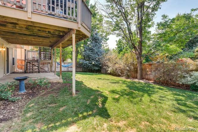 1672 Spring Water Place Highlands Ranch, CO 80129 - Photo 25 of 25 a view of a backyard with table and chairs under an umbrella