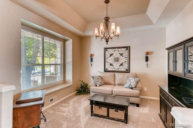 1672 Spring Water Place Highlands Ranch, CO 80129 - Photo 4 of 25 a living room with furniture and a chandelier