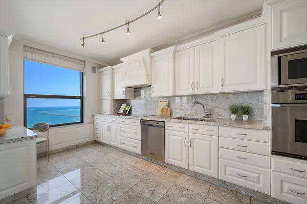 a large white kitchen with cabinets