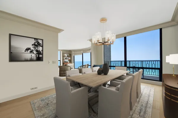 a view of a dining room with furniture a chandelier and wooden floor